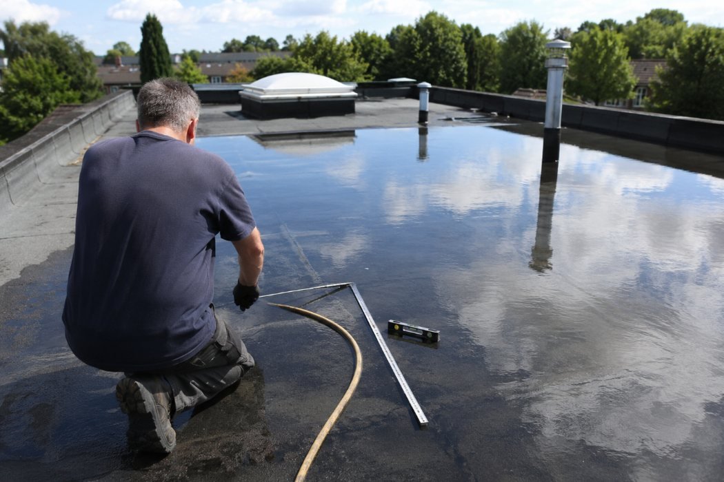 Técnico realizando una prueba de estanqueidad con agua sobre una cubierta plana